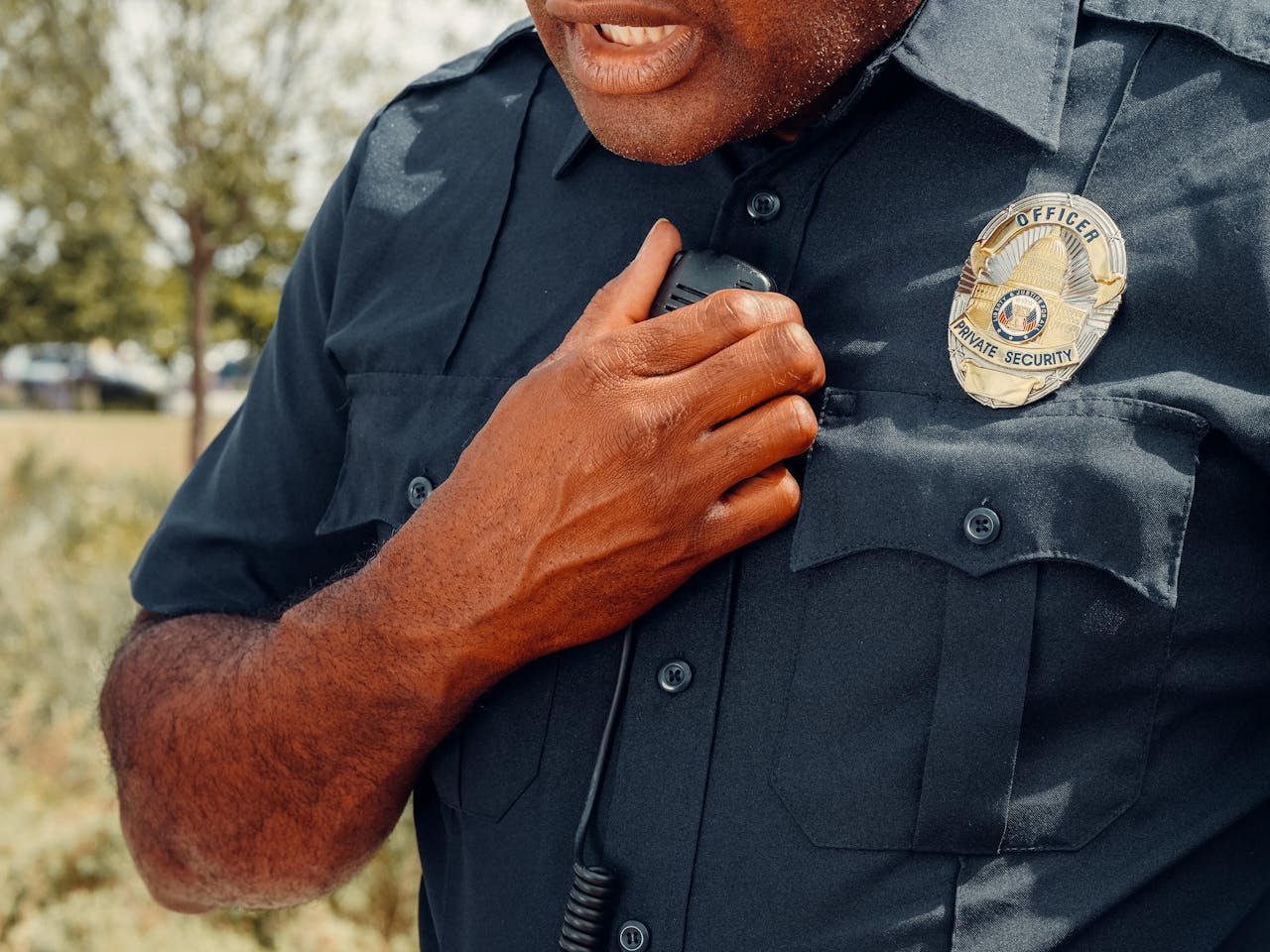 The Art of Drawing Readers In: Your attractive post title goes here Close-up of a security officer using a radio outdoors, showcasing professional security attire.
